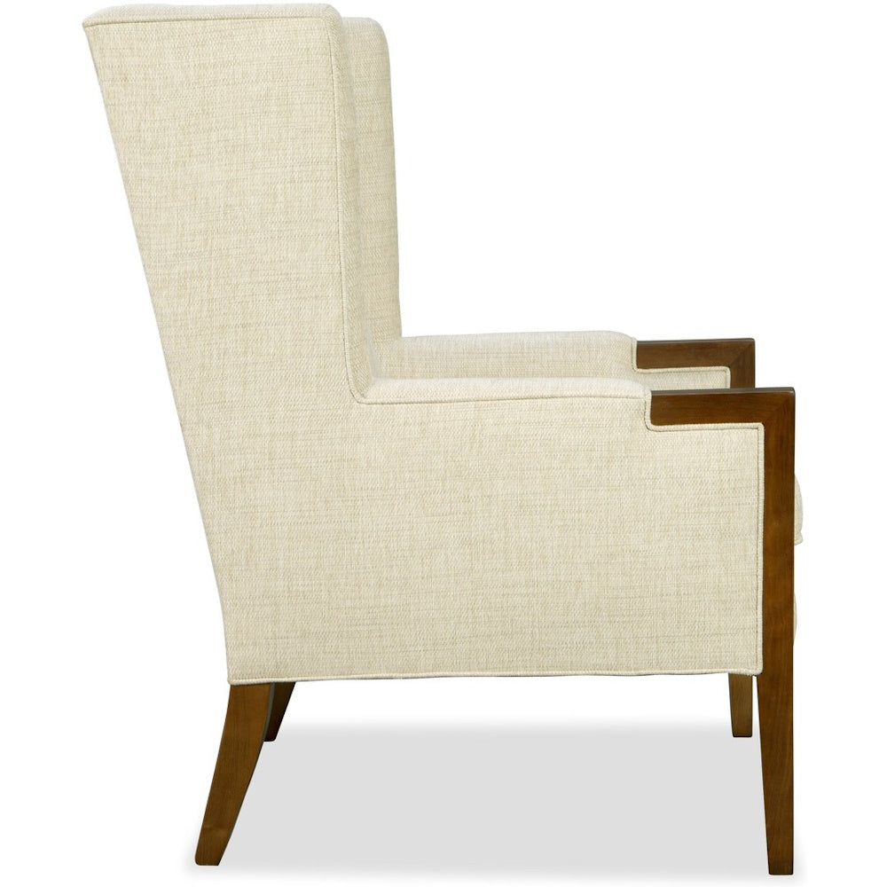 Side view of a high-back beige armchair featuring wooden armrest accents and dark legs.