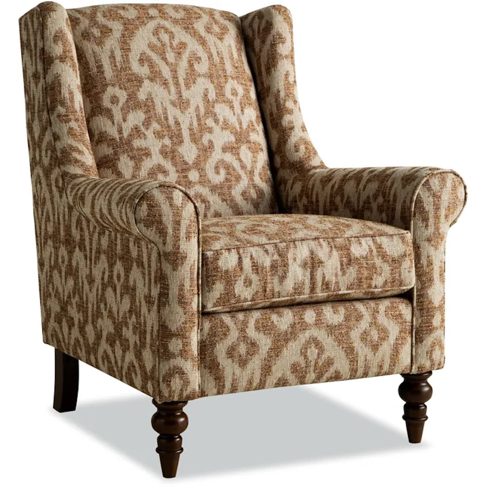 Upholstered wingback armchair with a brown and beige ikat damask pattern and turned wooden legs.