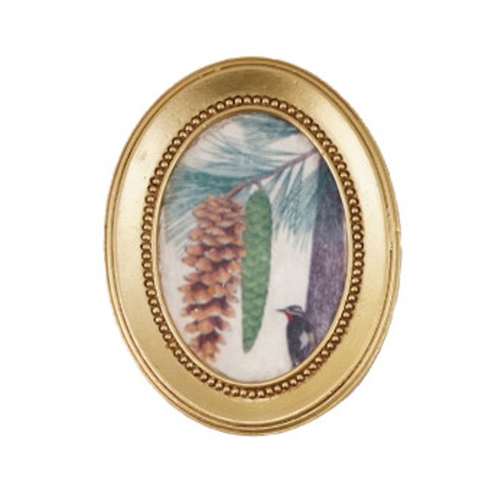 Mini oval gold framed magnet featuring pine cones, pine needles, and a small bird artwork.