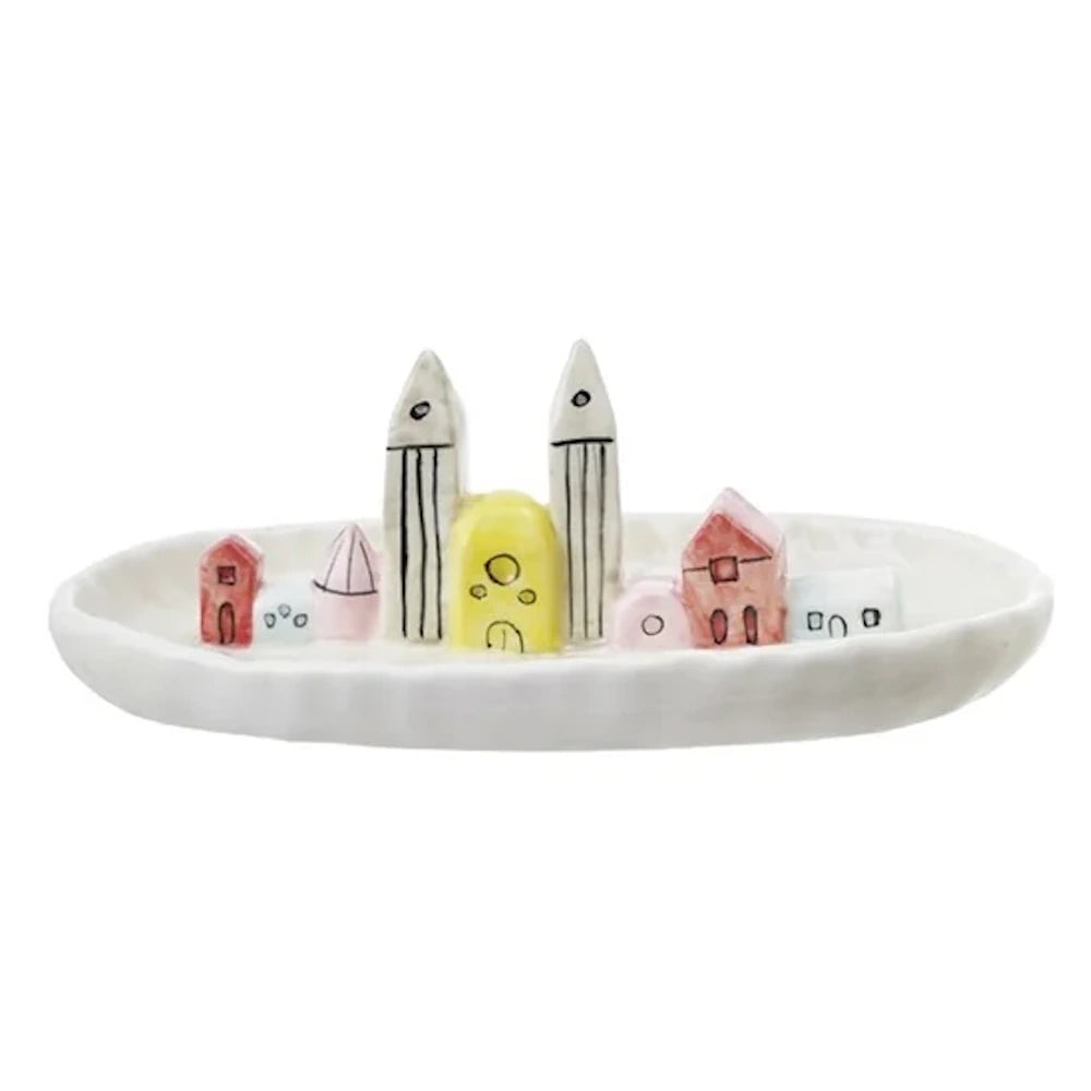 White oval ceramic tray featuring a row of miniature, colorful hand-painted buildings and towers.