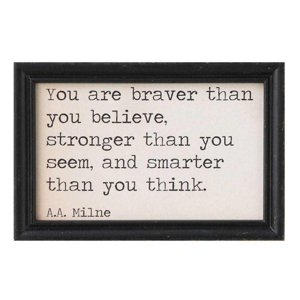 Wood wall decor with a black frame featuring an AA Milne quote: "You are braver than you believe..."