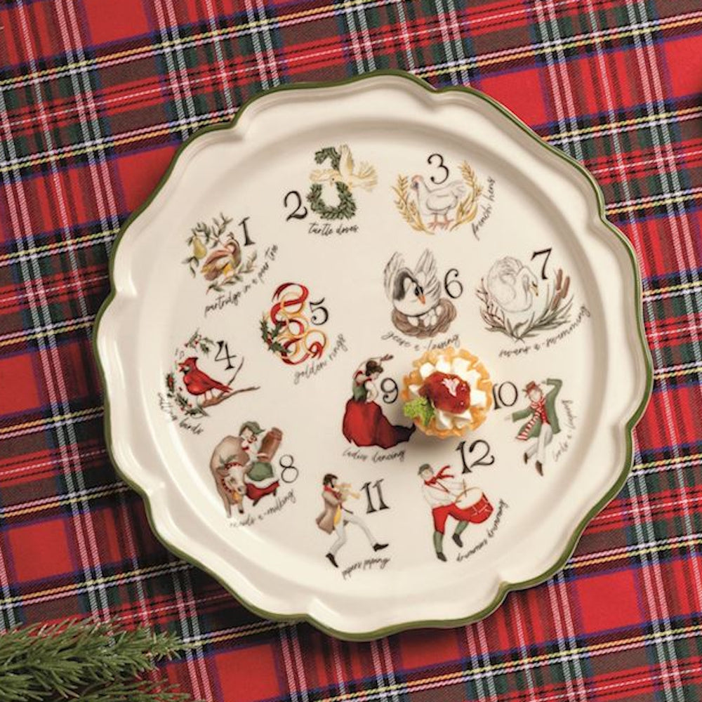 Twelve Days of Christmas scalloped round platter with a small dessert tart, on a red plaid tablecloth.
