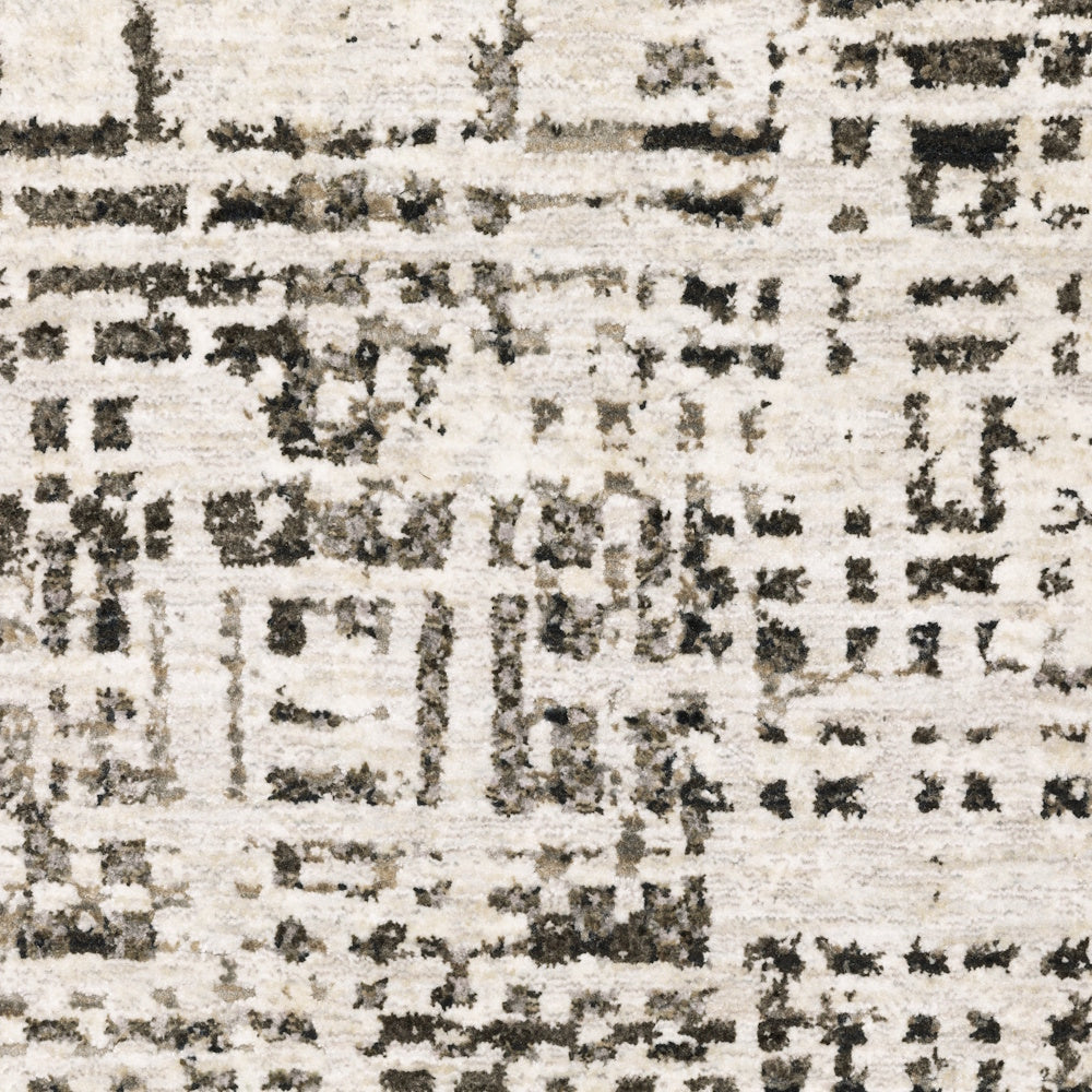 Extreme close-up of the gray and cream area rug showing the detailed texture of the abstract pattern.