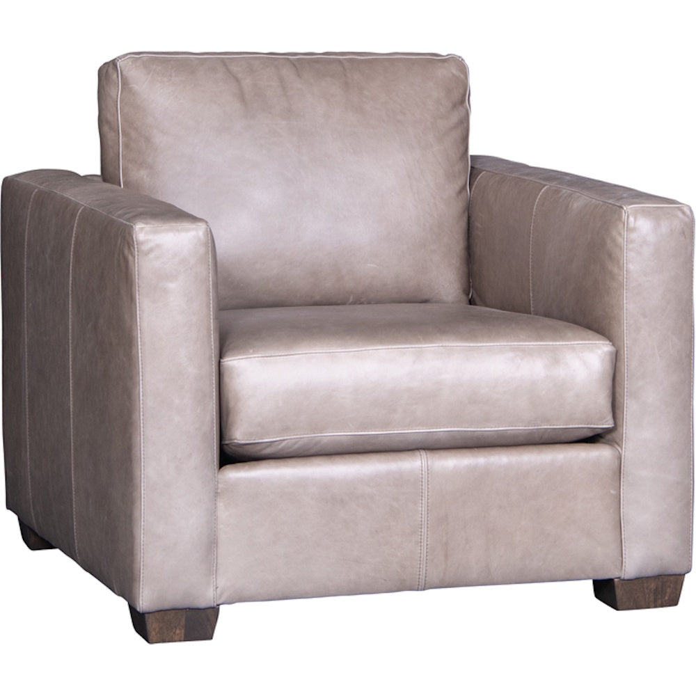 Brown leather armchair with box arms, loose back cushion, wide seat cushion and dark block feet.