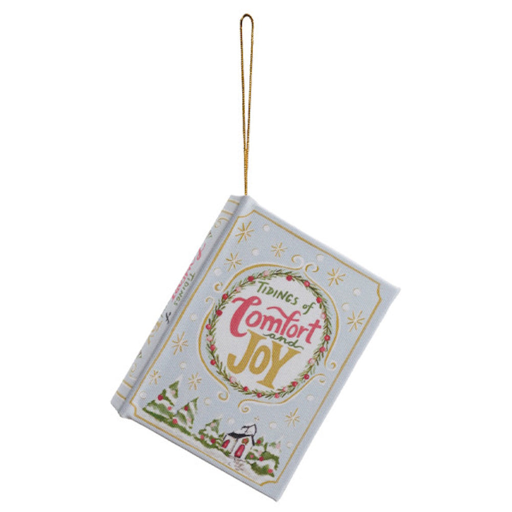 Light blue book ornament hanging from a gold string, with "Tidings of Comfort and Joy" cover text.