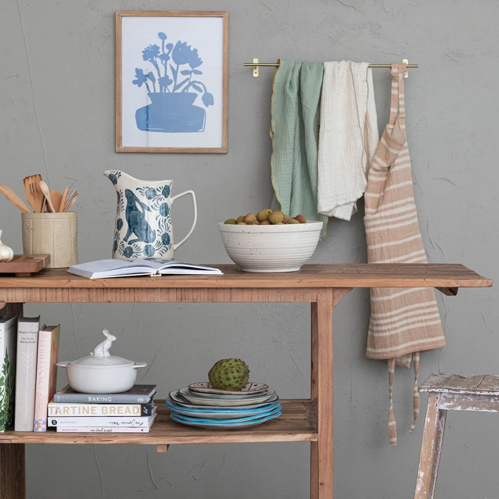 Hand-painted stoneware rabbit pitcher styled on a wooden kitchen island with cookbooks and ceramic bowls.
