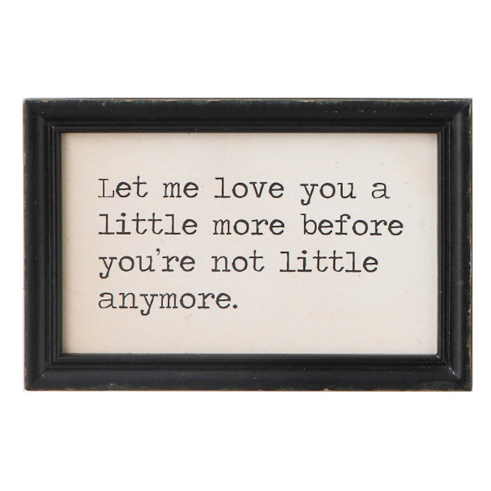 Framed sign reading "Let me love you a little more before you're not little anymore" in a black wood frame.
