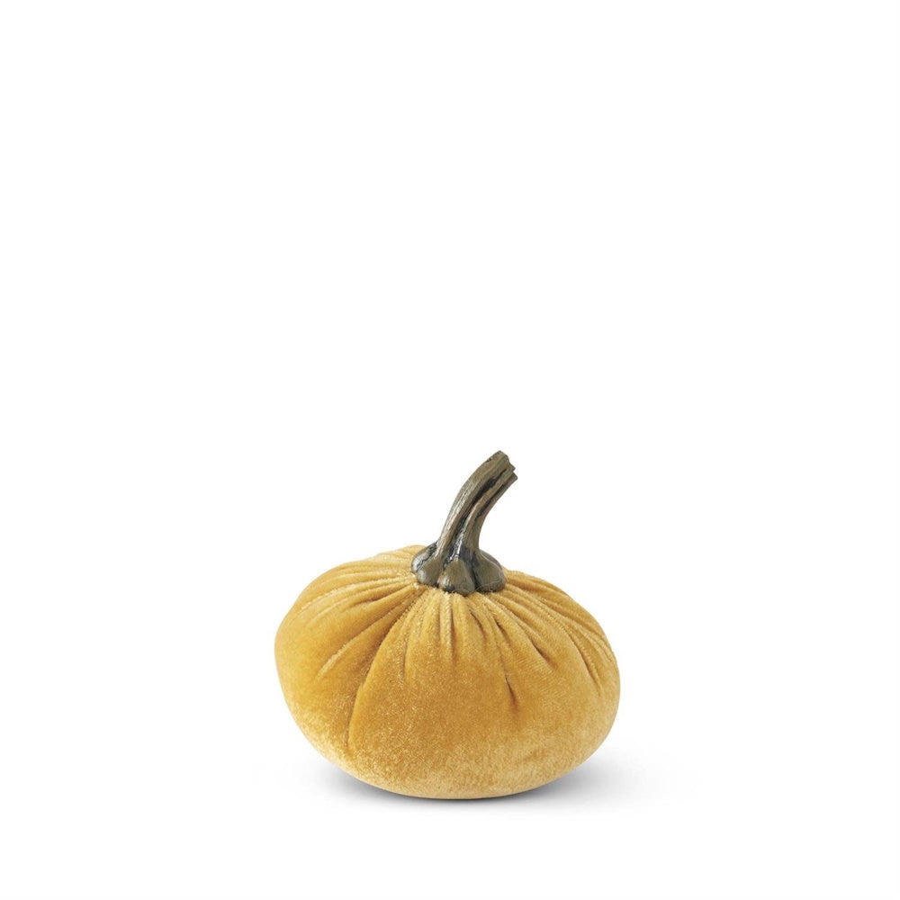 A mustard yellow velvet stuffed pumpkin decor piece with a dark stem on a white background.