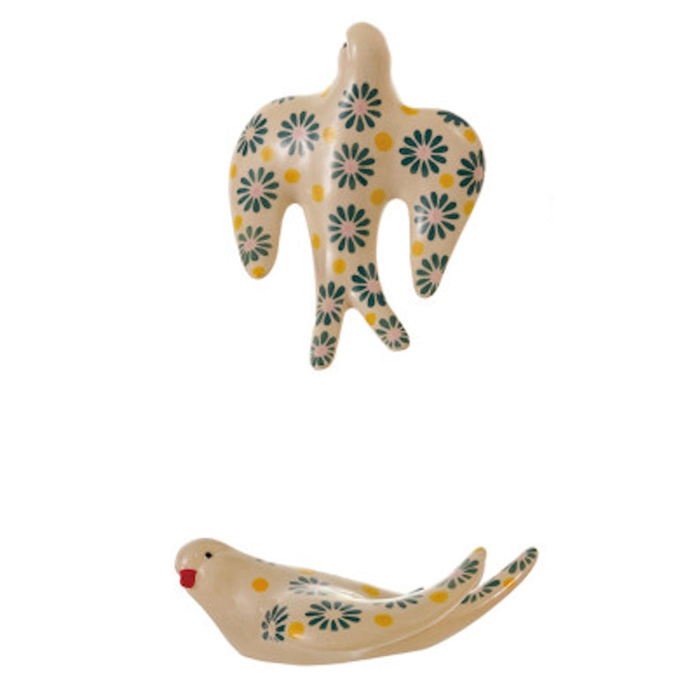 Two cream stoneware birds with hand-painted green flowers and yellow dots.