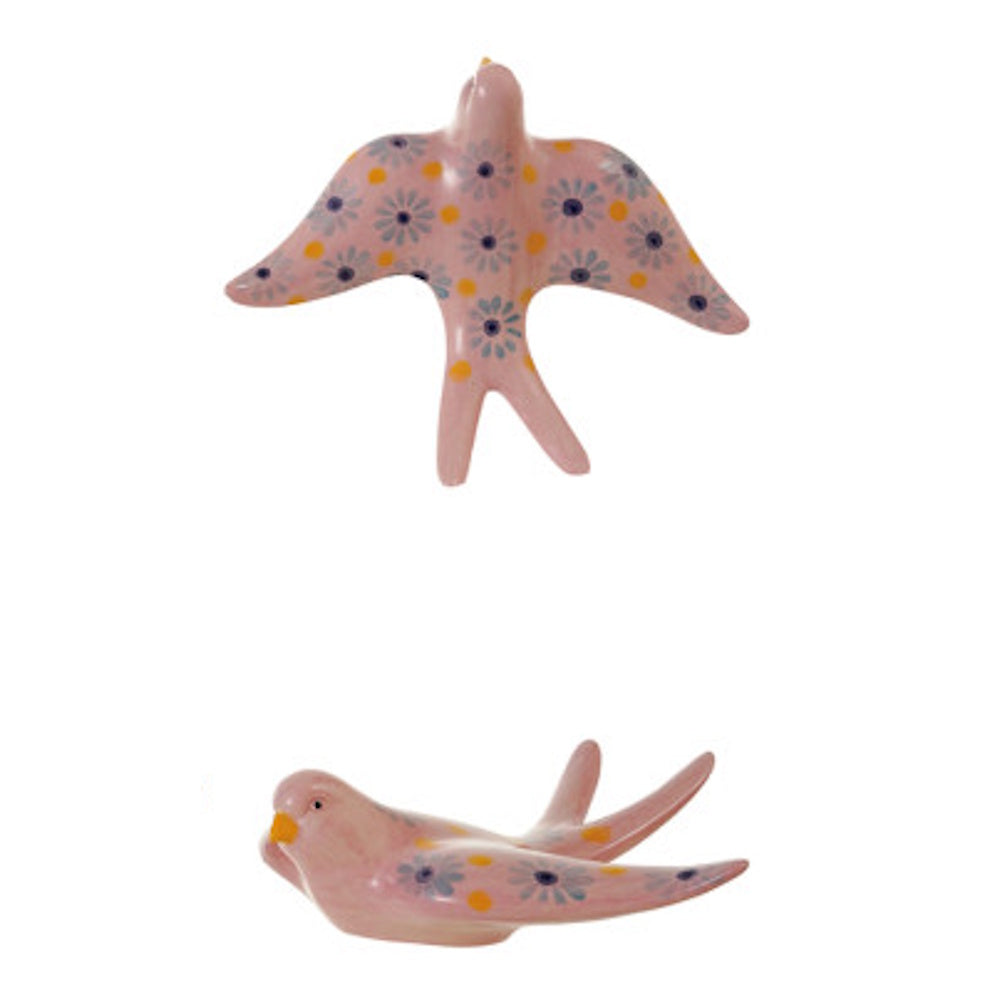 Pink stoneware bird wall decor with hand-painted blue flowers and yellow dots, shown from top and side views.