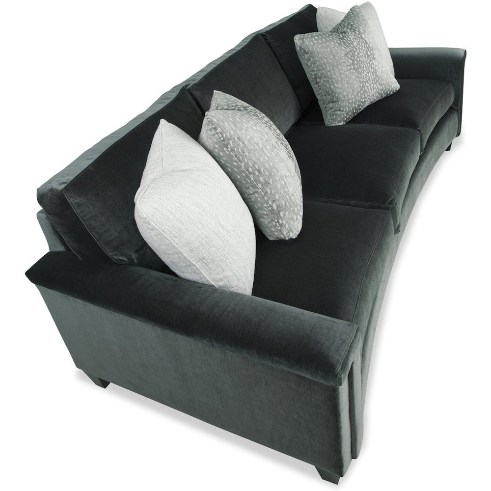 High-angle view of a dark grey three-cushion velvet sofa with light accent pillows.