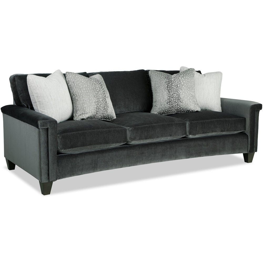Dark grey velvet three-cushion sofa styled with patterned accent pillows on a white background.