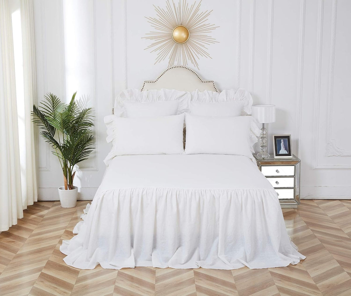 Ruffled white queen bedspread styled on a bed