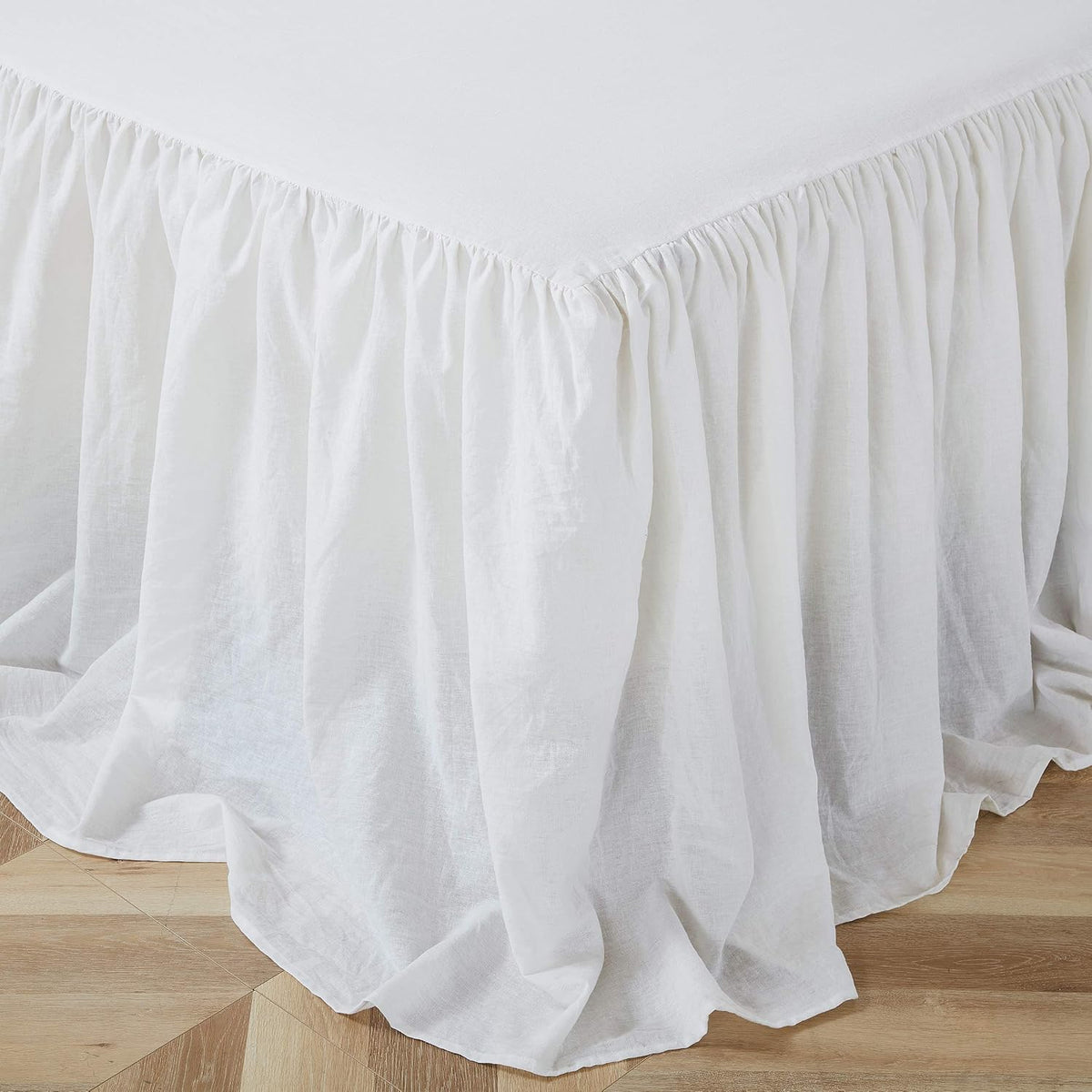 Close-up of the ruffled white queen bedspread showing fabric texture