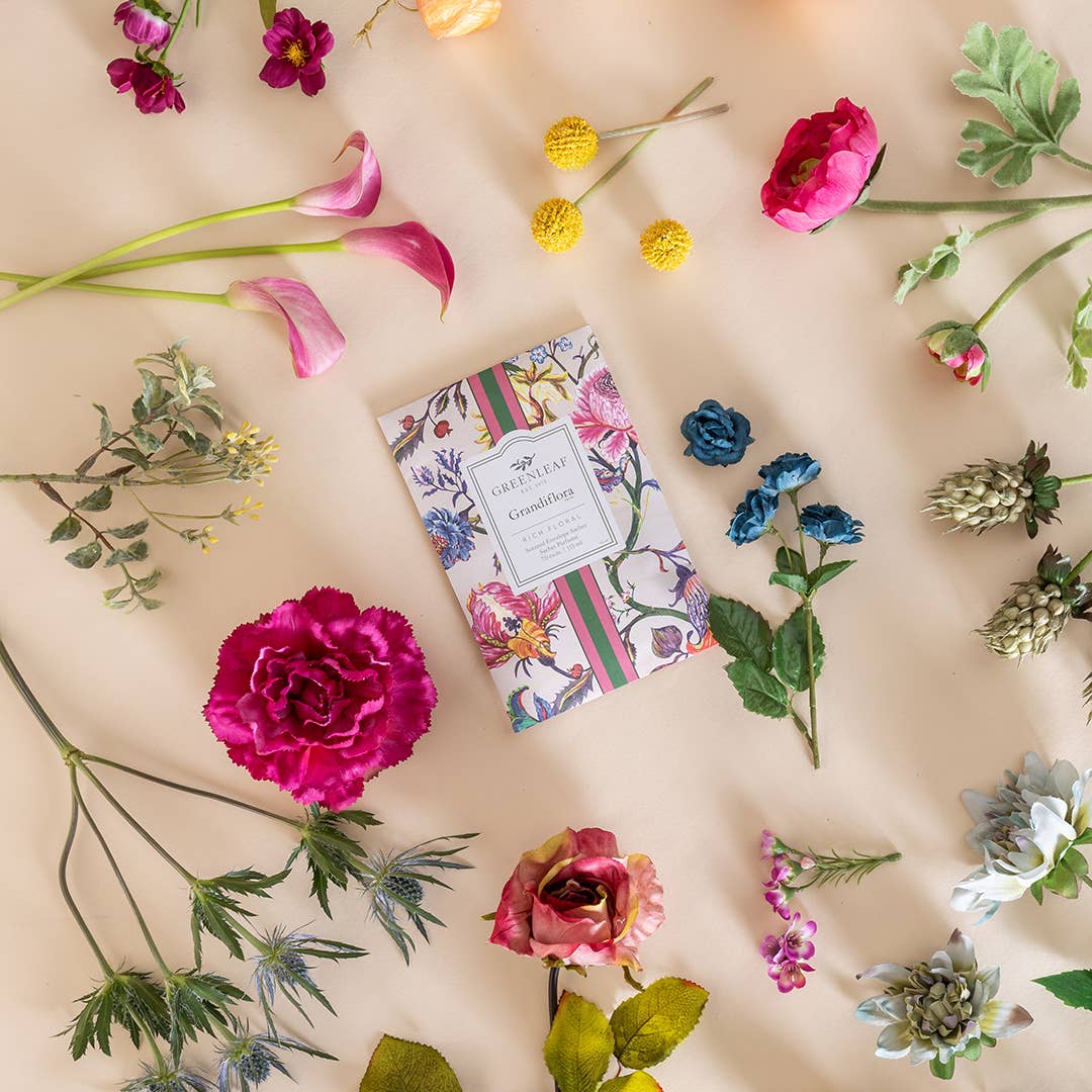 Floral-themed product packaging surrounded by colorful flowers on a beige background
