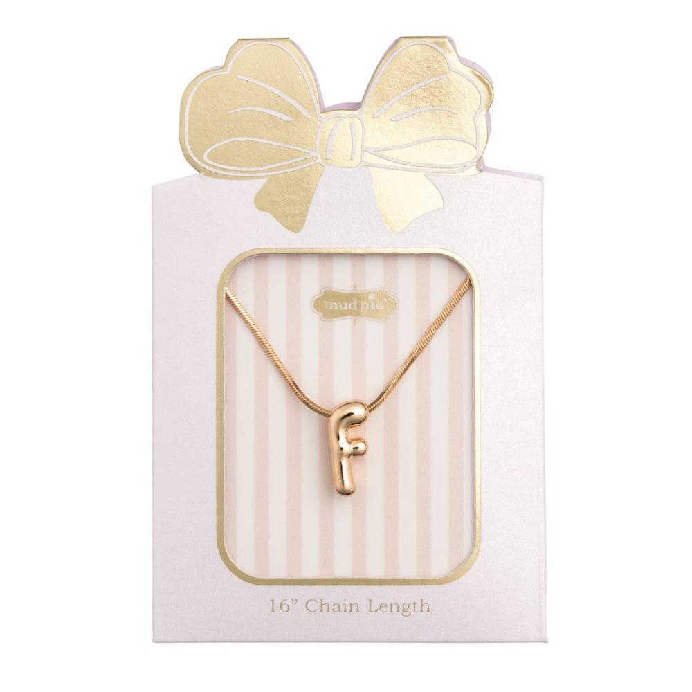 Gold initial "F" pendant necklace packaged in a pink box with a gold bow design.