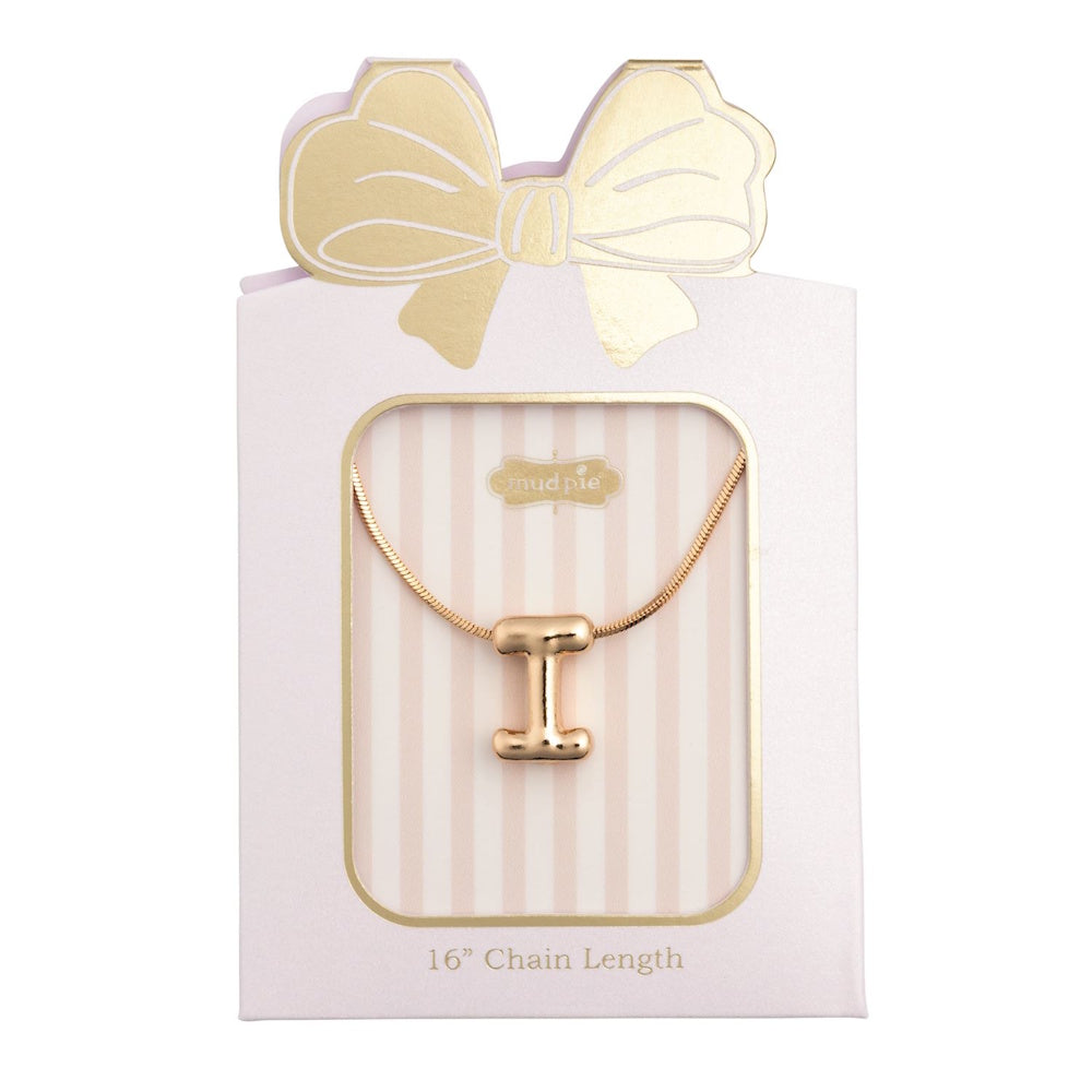 Gold initial "I" pendant necklace packaged in a pink box with a gold bow design.