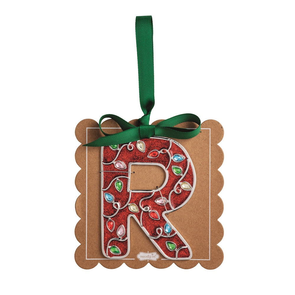 Sparkly red Christmas initial ornament letter R mounted on a scalloped brown card with a green hanging ribbon.