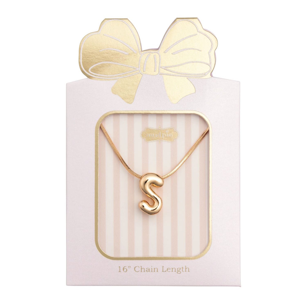 Gold initial "S" pendant necklace packaged in a pink box with a gold bow design.