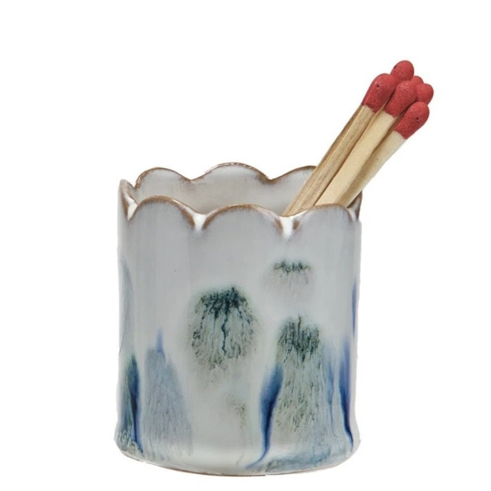Scalloped white ceramic match striker filled with matches featuring blue reactive glaze accents.