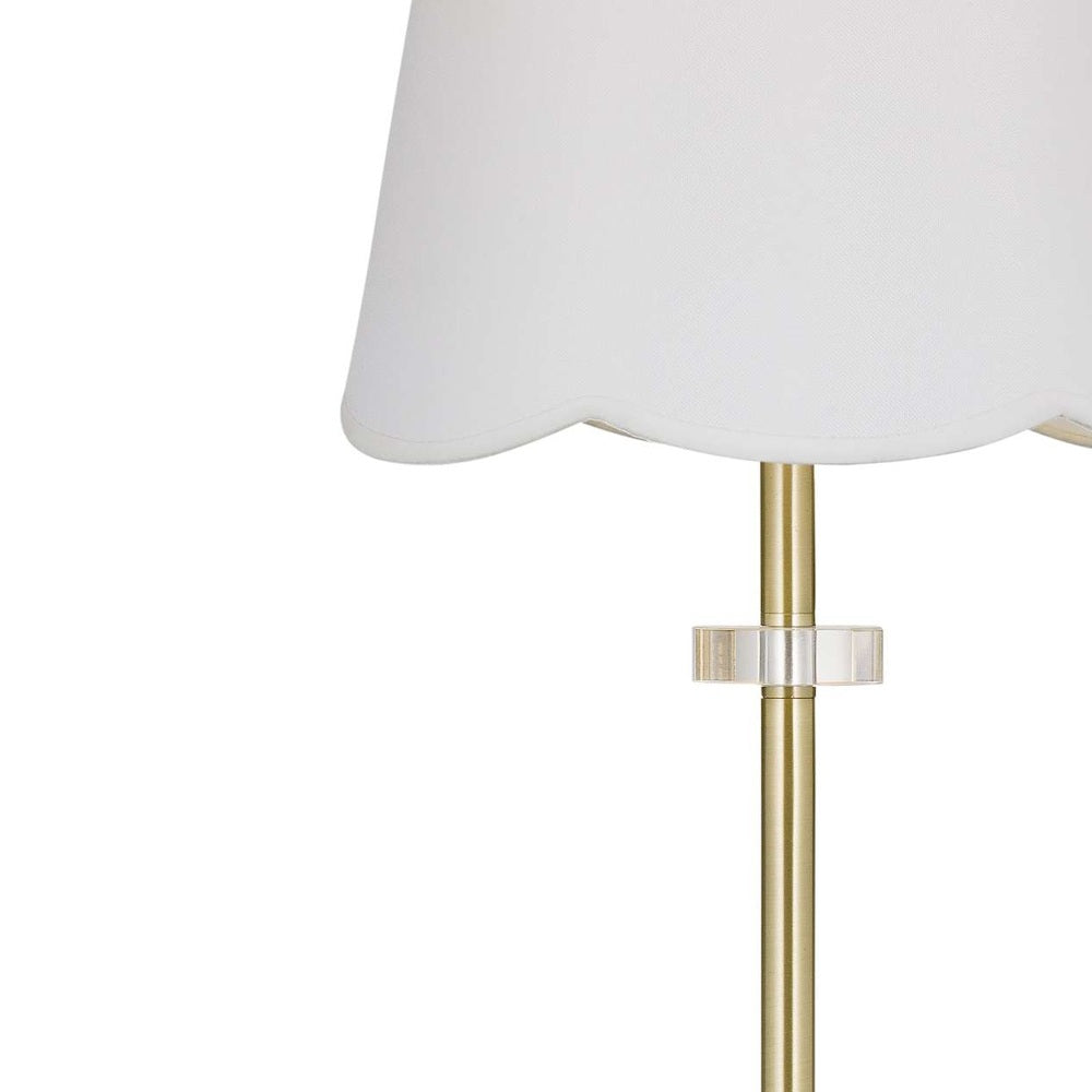 Modern brass table lamp with white scalloped shade and crystal accent.
