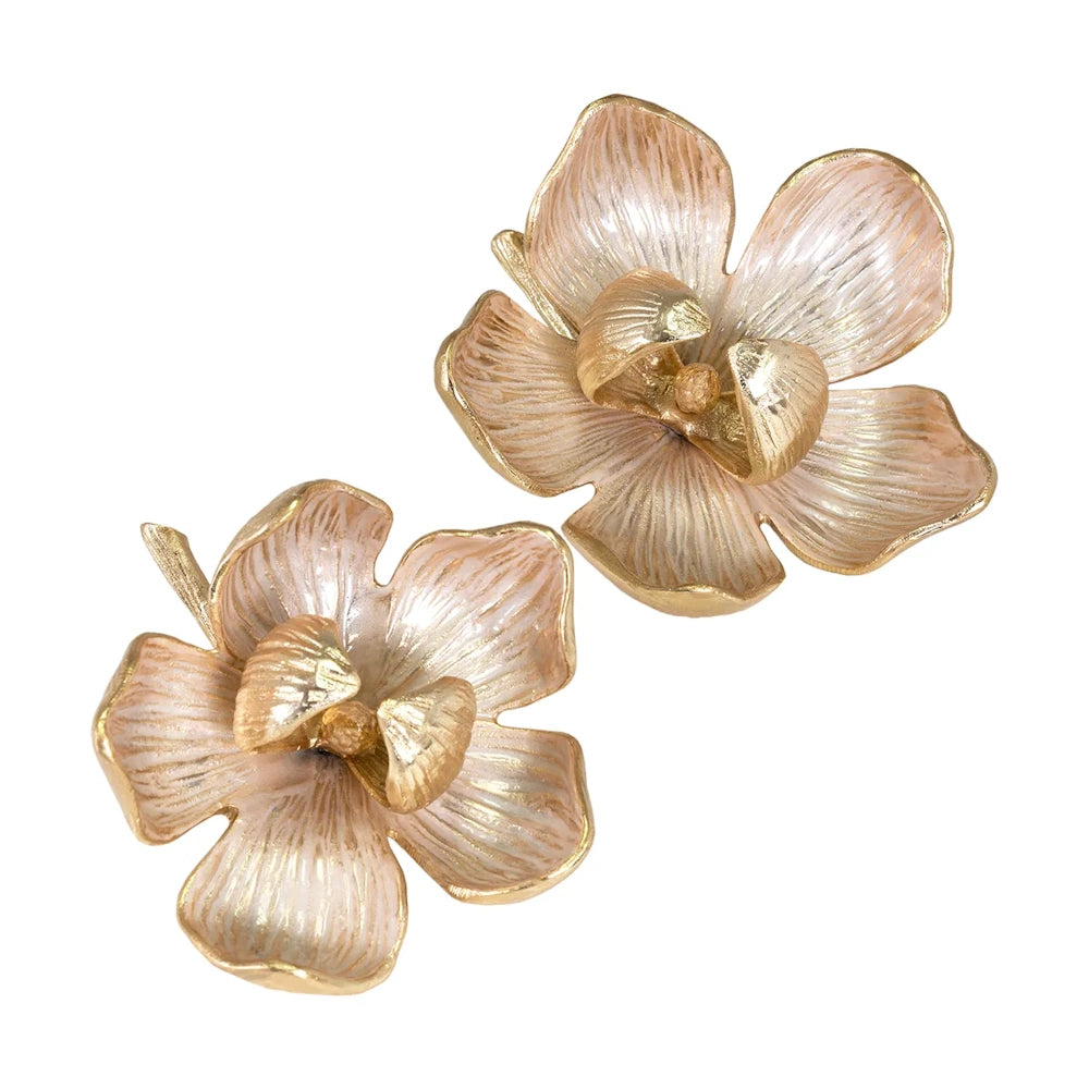 Two elegant, gold-rimmed flower sculptures with pale pink, textured petals and a metallic gold center.