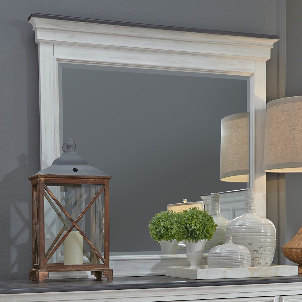 Rectangular off-white mirror with a dark top cap molding, styled on a dresser with decor.