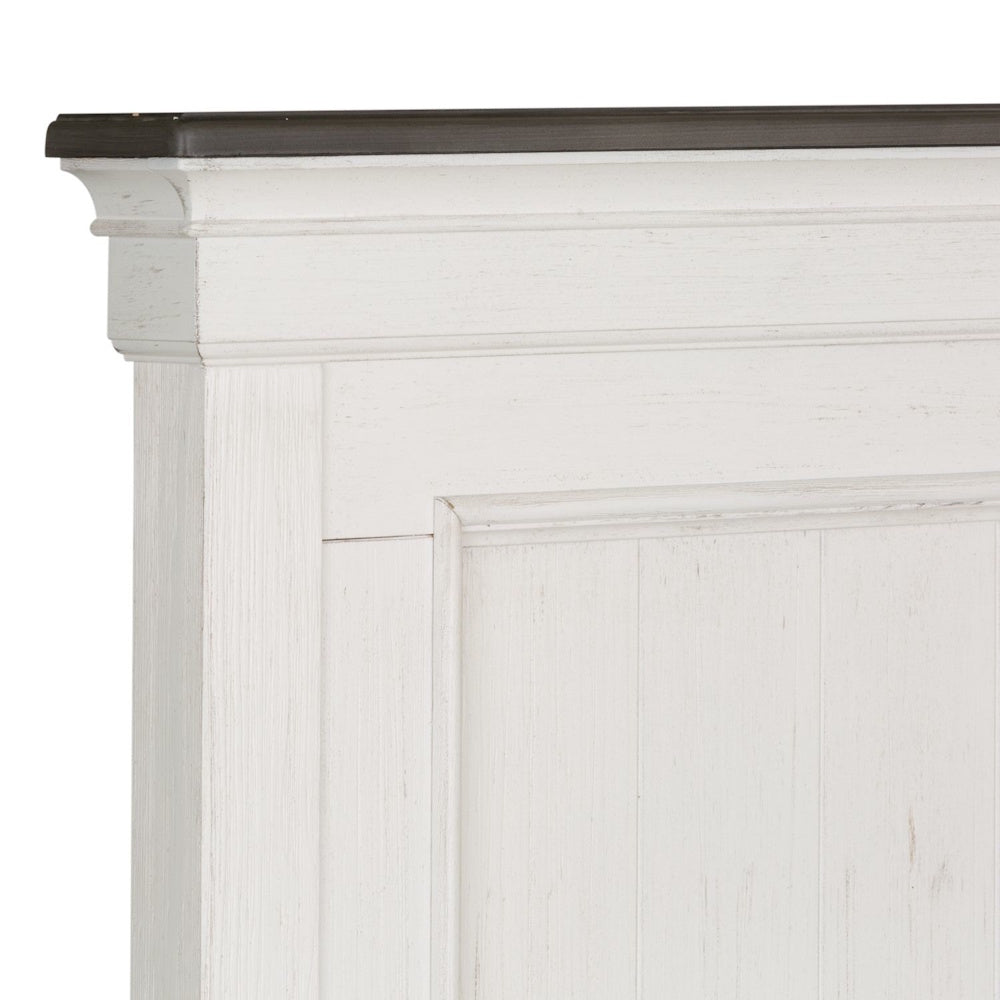 Close-up of distressed white wooden headboard corner featuring dark cap molding detail.