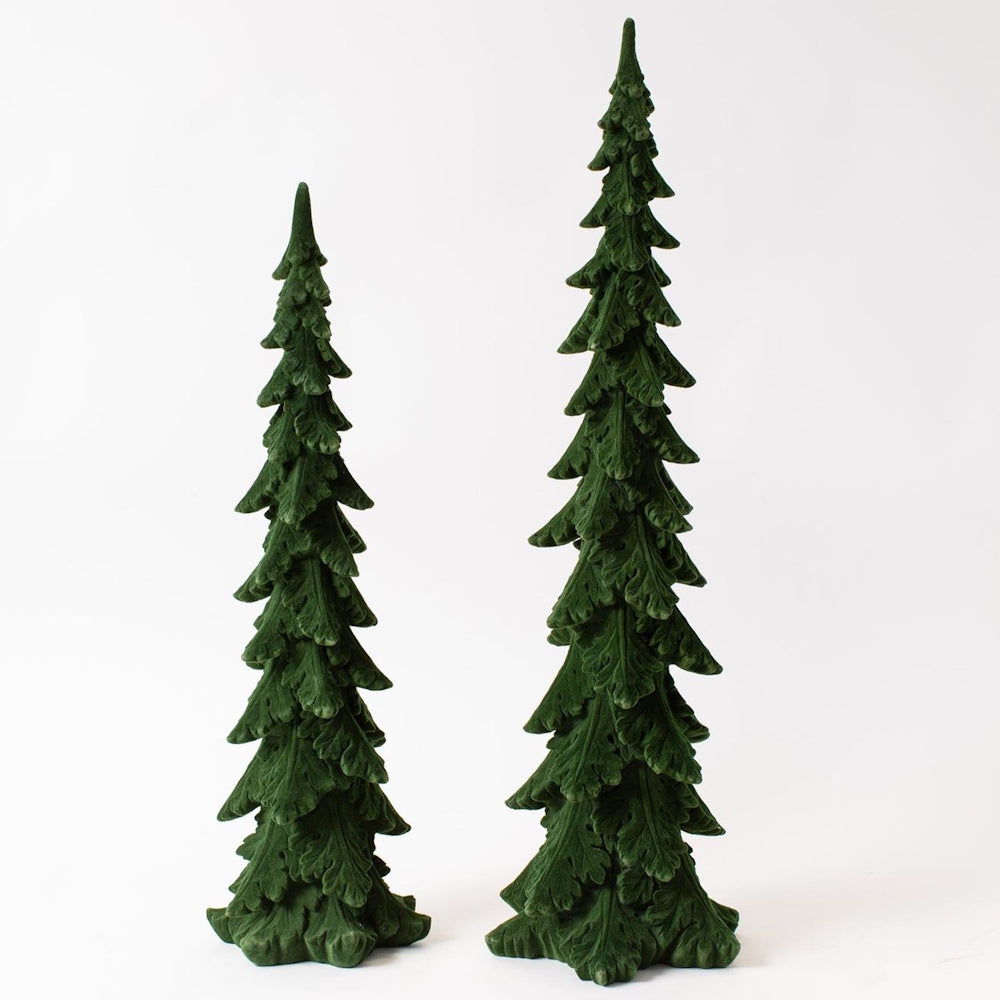 Two miniature, slender green pine tree figurines standing on a plain white background.