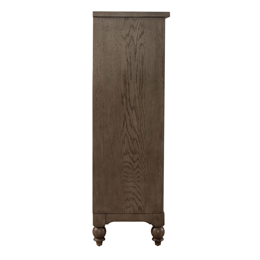 Side profile view of a brown wooden five-drawer chest featuring natural wood grain and turned feet.