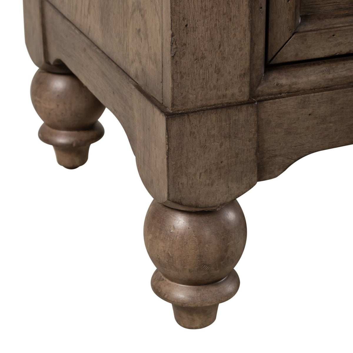 Close-up of the wooden dresser base showing the turned bun feet and carved frame details.