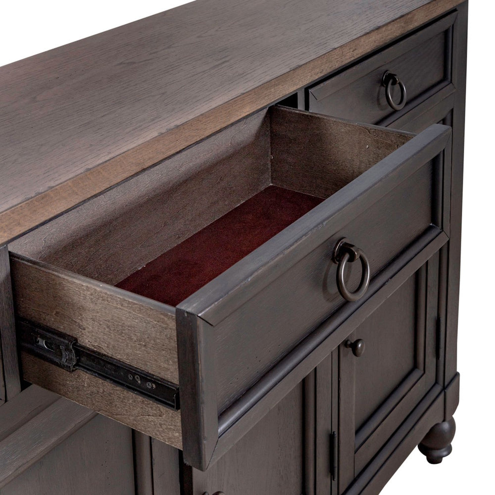 Open drawer of a dark wooden buffet showing brown felt lining and ring pull hardware.