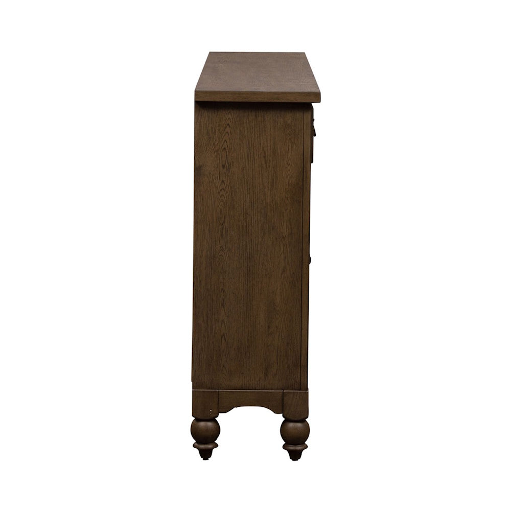 Side profile view of a slim, rustic brown wooden farmhouse buffet cabinet showing turned bun feet.