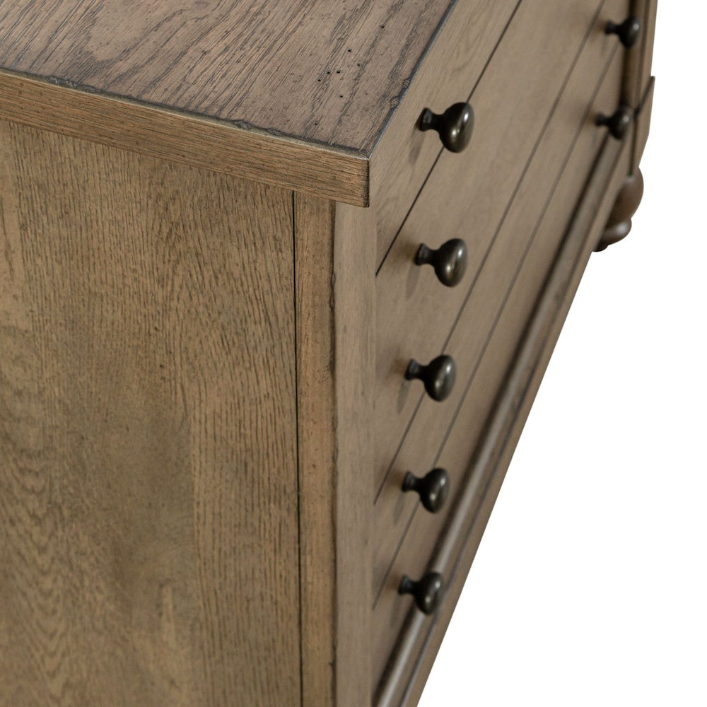 Close-up of a wooden file cabinet showing rich wood grain texture and dark metal knobs.