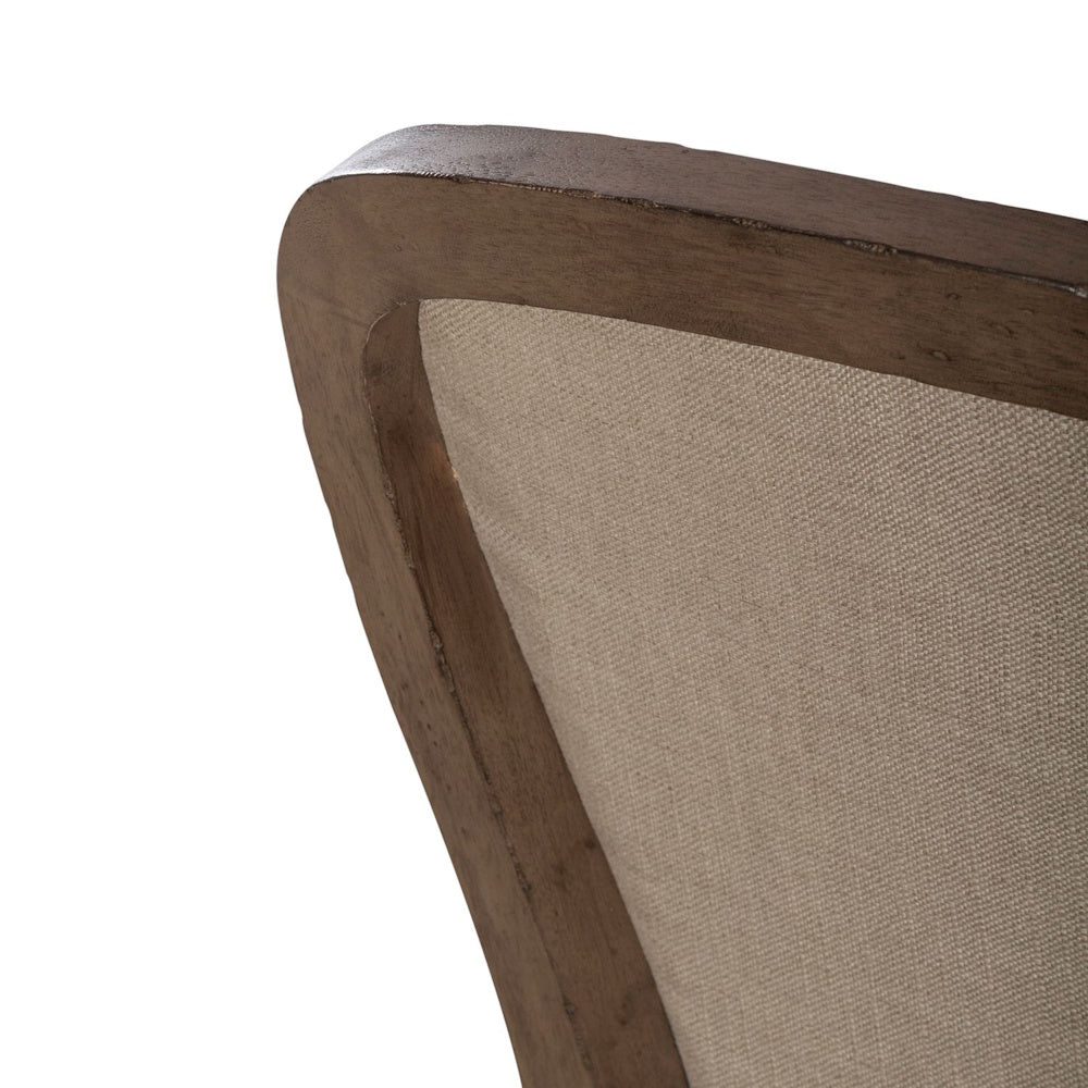 Americana farmhouse upholstered side chair closeup showing the top curve of the wood frame and beige fabric.