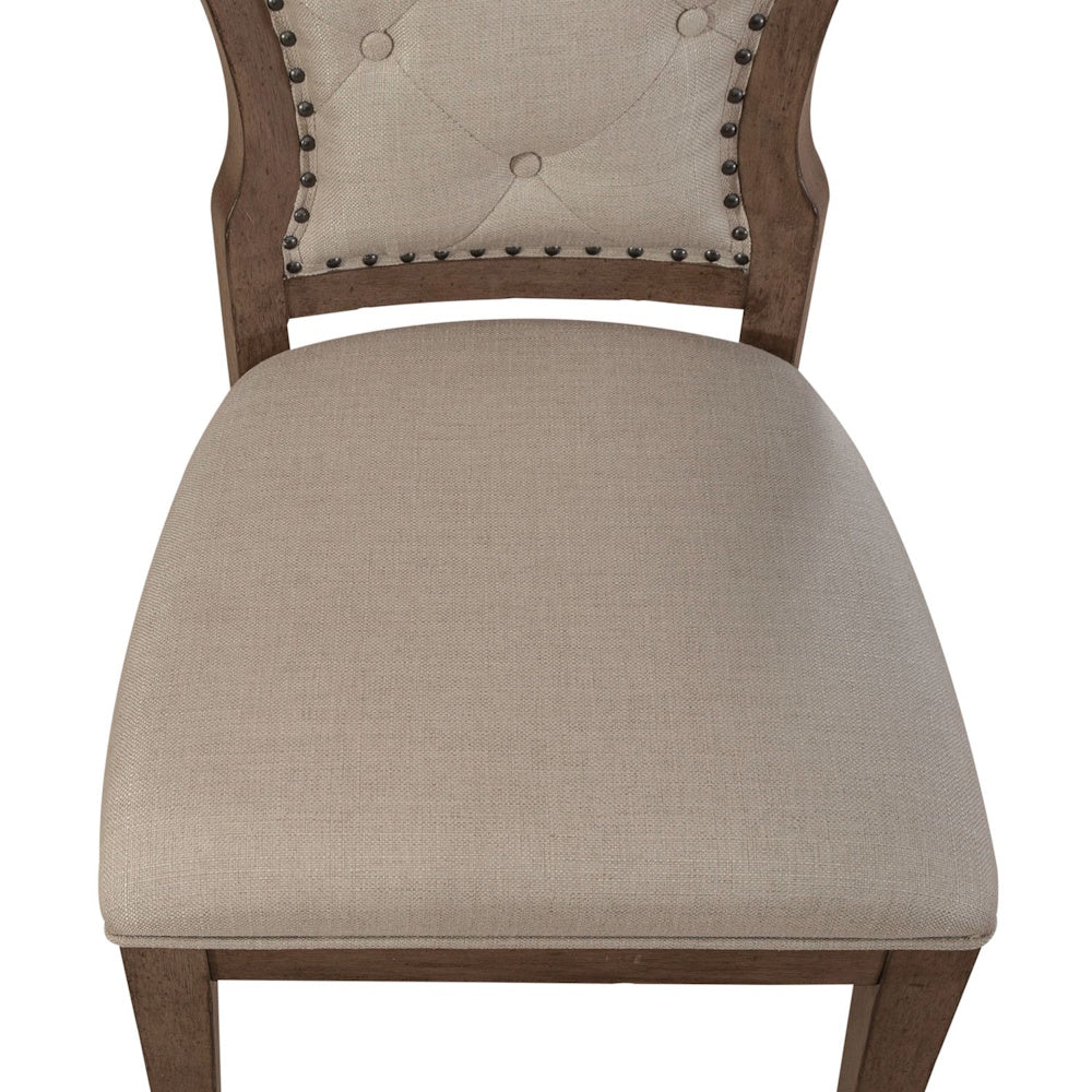 Upholstered cushion and tufted back of an Americana farmhouse dining side chair.