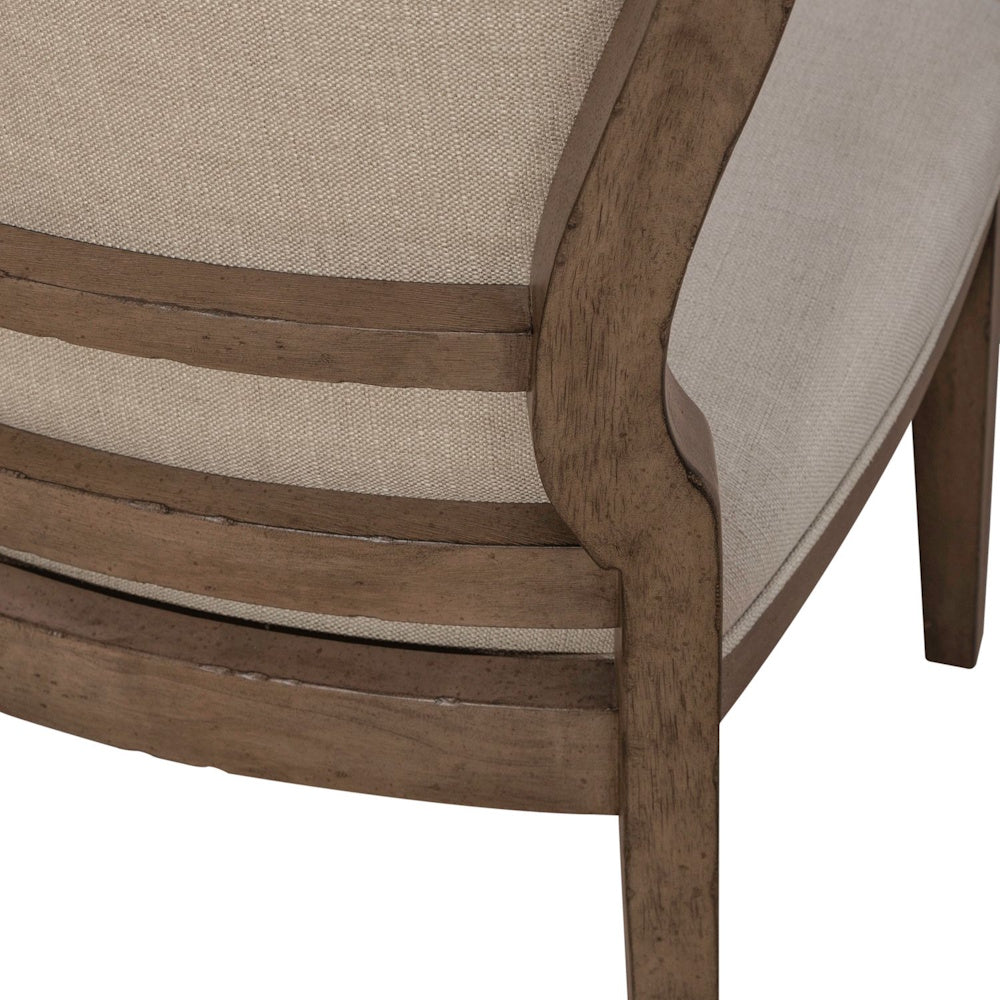 Americana farmhouse upholstered dining chair with a close up of the wooden back frame and beige fabric.