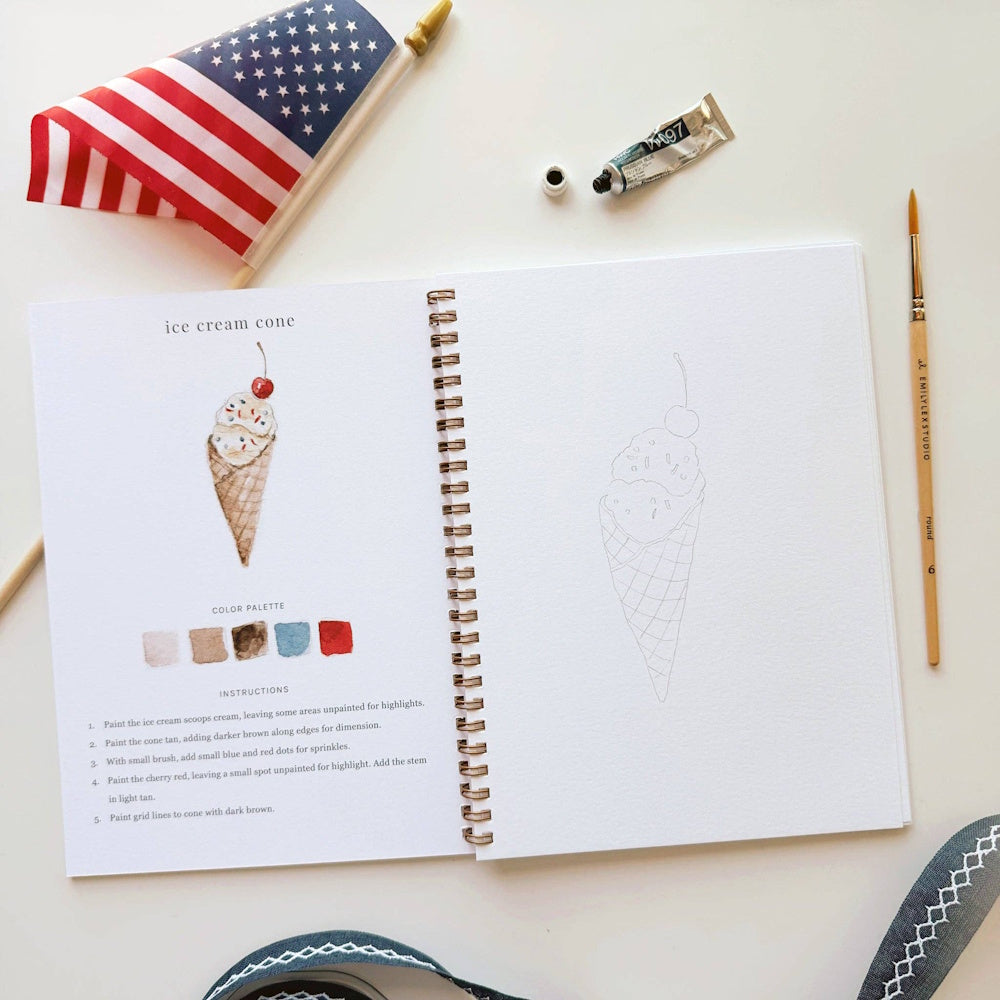 Watercolor workbook page showing how to paint an ice cream cone with an American flag and paintbrush nearby.