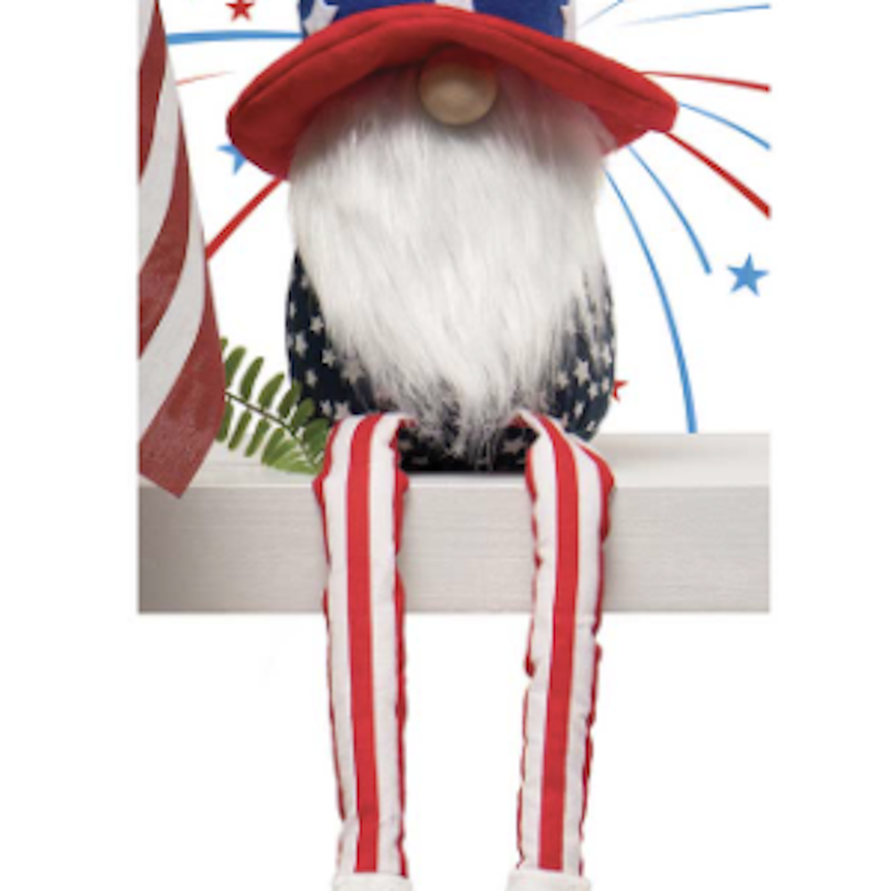 Patriotic gnome decoration with a long white beard and striped legs dangling over the edge of a shelf.
