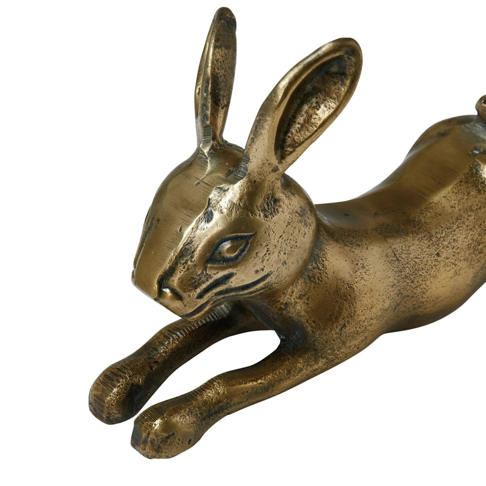 Close-up of a cast aluminum rabbit figurine with an antique brass finish on a white background.