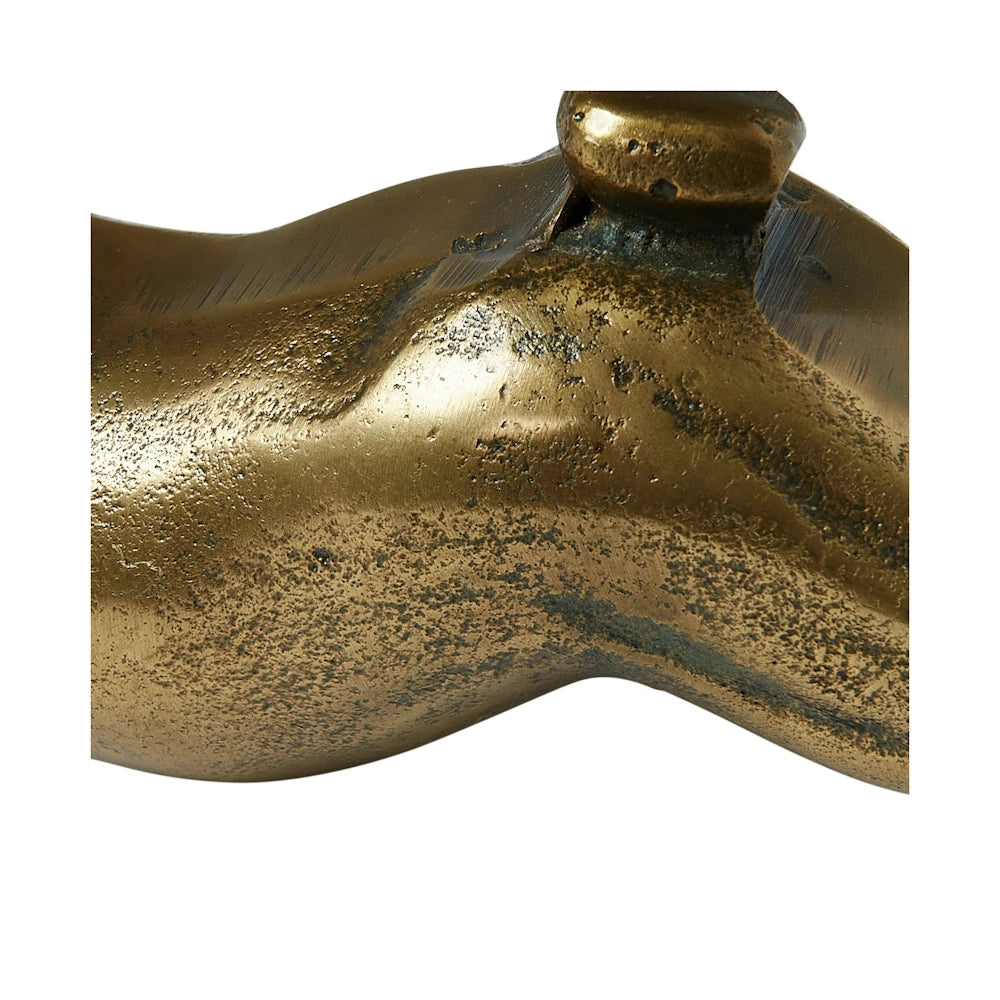 Close-up of an antique brass finish on a cast aluminum rabbit figurine showing textured metallic detail.