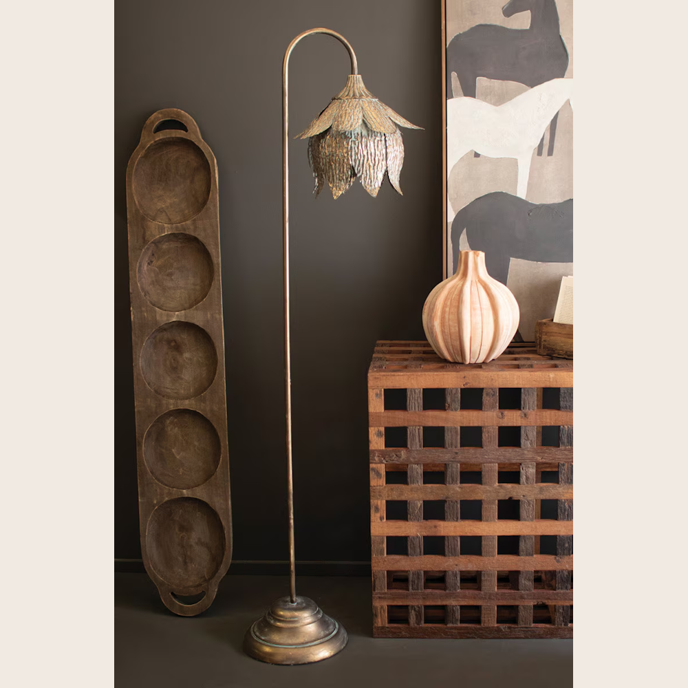 Antique brass tulip floor lamp with a scalloped metal shade standing next to rustic wooden decor and horse wall art.