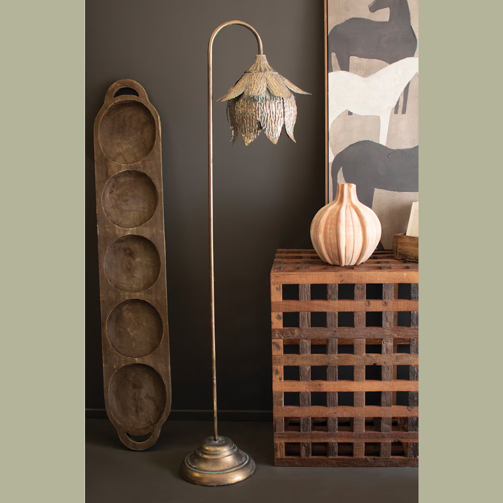 Antique brass tulip floor lamp with a scalloped metal shade standing next to rustic wooden decor and horse wall art.