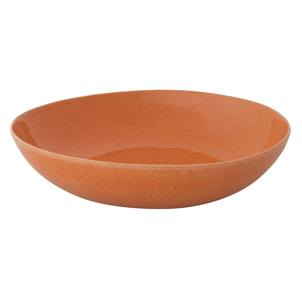 Shallow apricot-colored stoneware bowl with a smooth matte glaze finish on a white background.