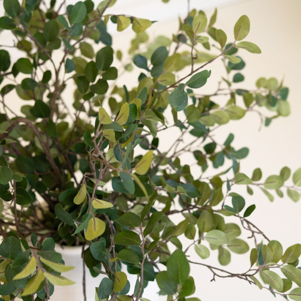 Detailed close-up of small green leaves on artificial crape myrtle spray stems.