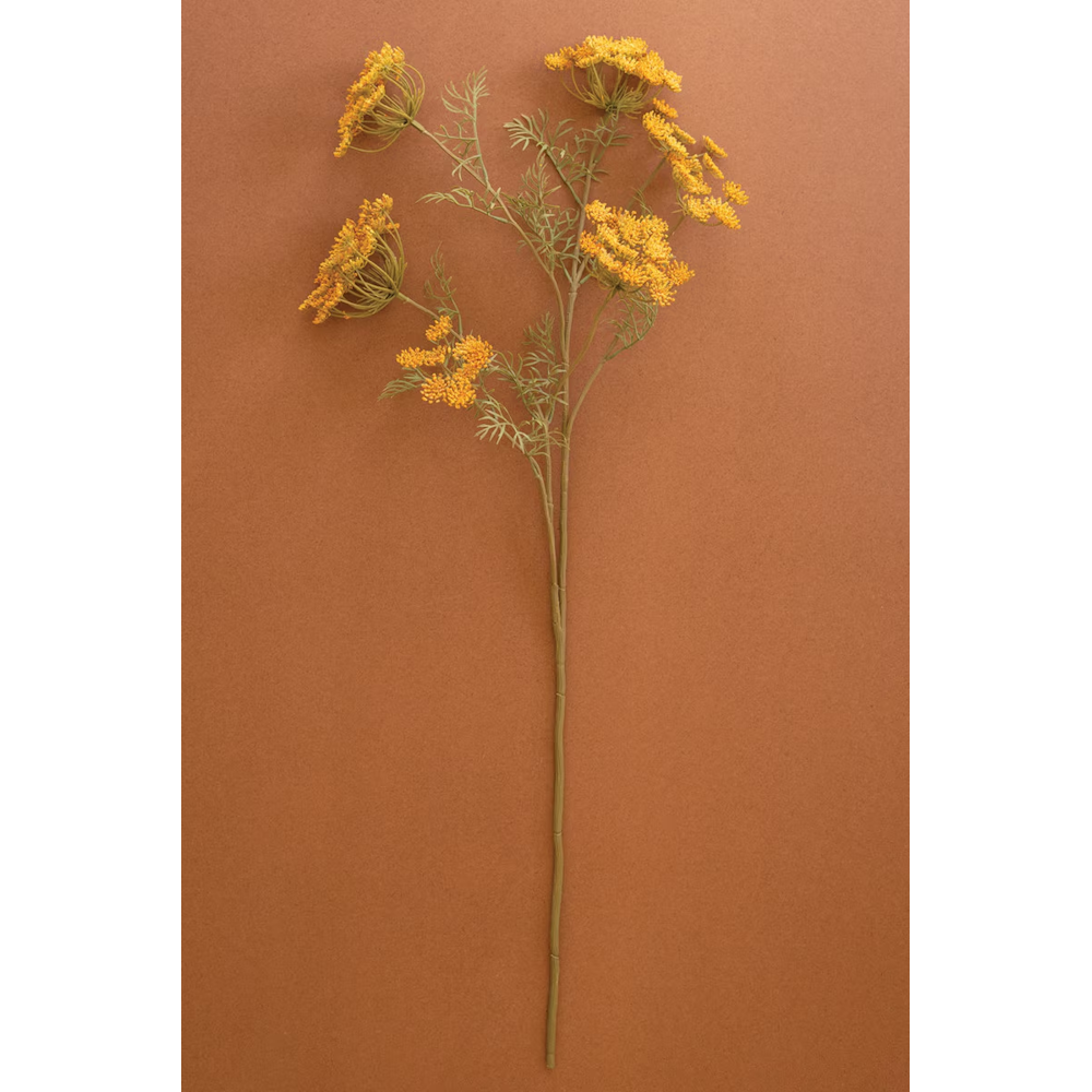 Single artificial yellow lace flower stem displayed against a warm terracotta background.