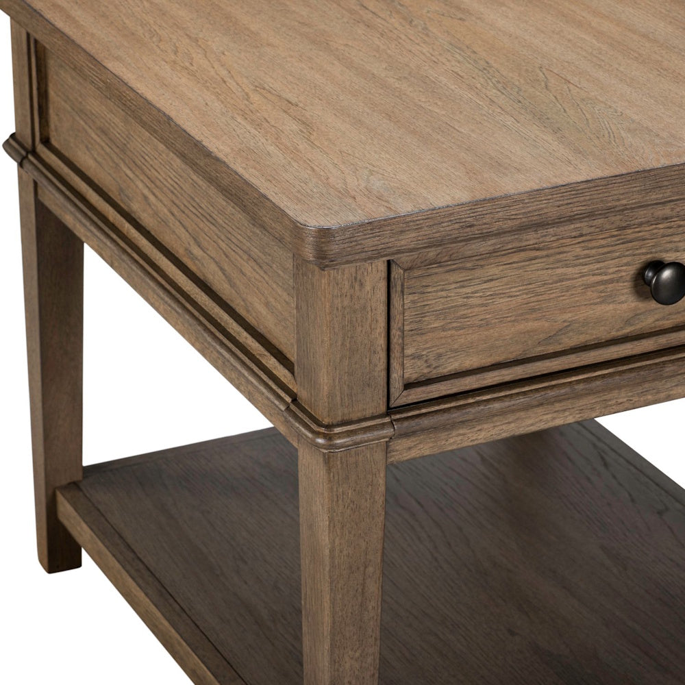 Close-up corner of a brown wood end table with a drawer, dark knob pull, and bottom shelf.