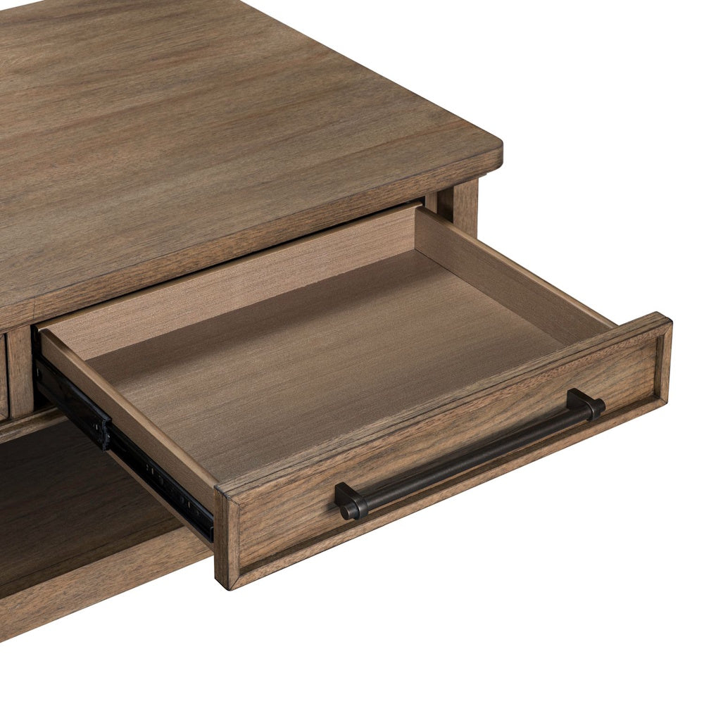 Close-up of a rustic wooden coffee table with its open drawer, featuring a dark metal bar handle.
