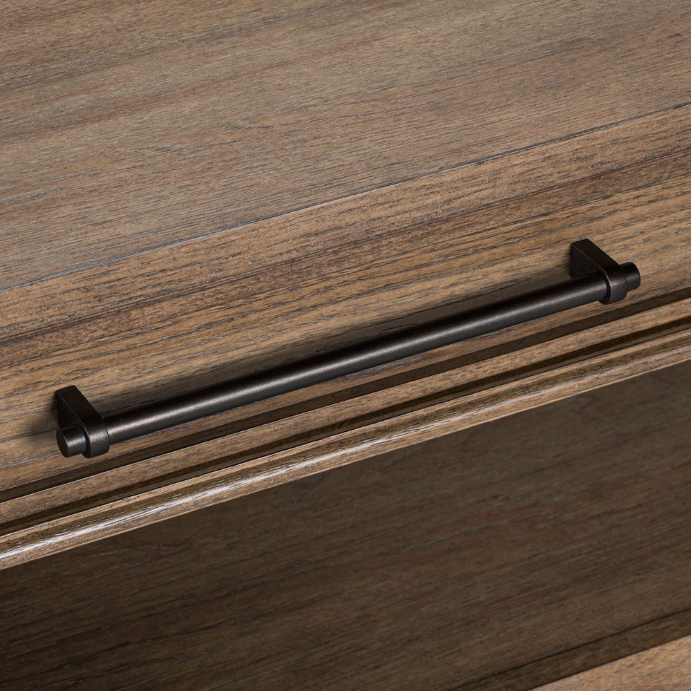 Close-up of a weathered wood drawer featuring a sleek black metal bar handle pull.