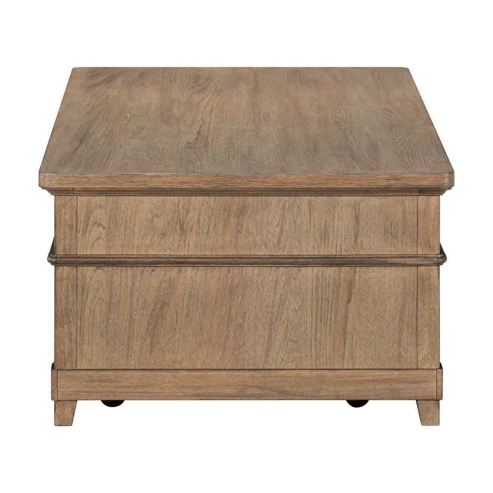 Side view of a rectangular, light-brown wood coffee table with paneled sides and small caster wheels.